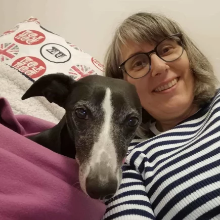 Comment un Whippet a changé ma vie : Un Whippet noir et blanc tout contre une femme souriante illustrant parfaitement le sujet "Comment un Whippet a changé ma vie".