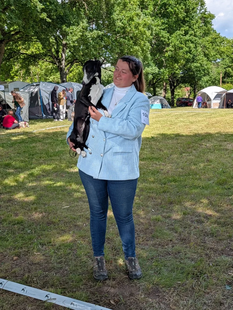 Une éleveuse tenant un Whippet noir et blanc lors de la RE 2026 de Vieure.